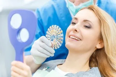 woman choosing a color for her dental veneers at Dat Complete Dentistry
