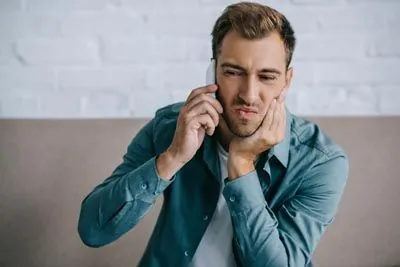 man calling Dat Complete Dentistry for emergency dental care